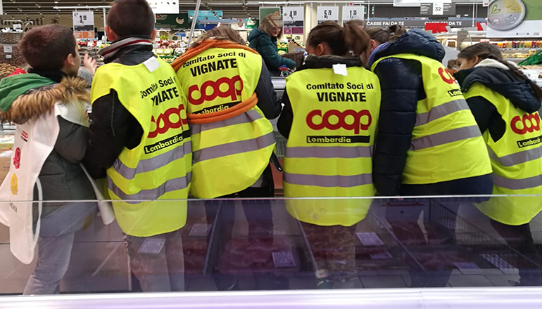 Bambini in una corsia della Coop vestiti con il gilet del comitato soci di Vignate