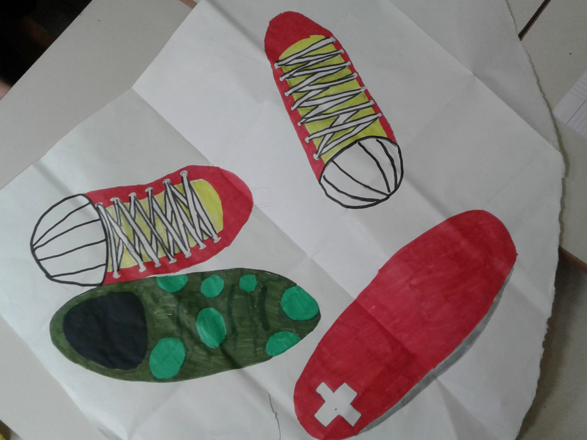 Disegno fatto da un bambino di scarpe da ginnastica, sacco a pelo e kit di pronto soccorso
