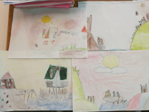 Disegni dei bambini che raffigurano una barca che arriva su un'isola